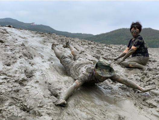 People sliding across the tidal mudflat